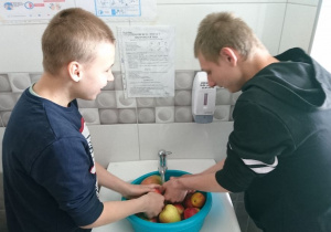 Kacper i Adam dokładnie myją owoce.